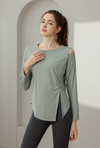 Detail of grey-green yoga top featuring shoulder cutout and side drawstring slit design