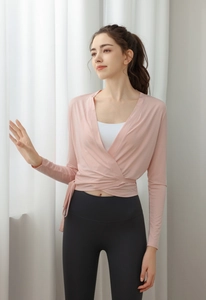 Detail view of pink wrap yoga cardigan with waist tie over a white sports top