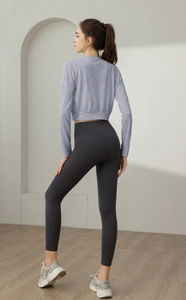 Close-up back view of light purple cropped yoga top and high-waisted grey leggings