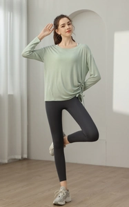 Detailansicht eines hellgrünen Yoga-Oberteils mit seitlichem Kordelzug und High-Waist-Leggings