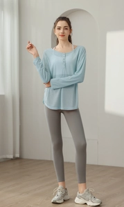 Détail du haut de yoga bleu clair à manches longues et legging de sport gris ajusté