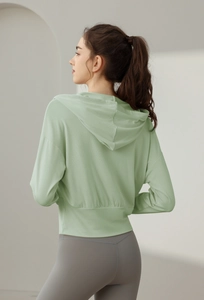 Vue arrière du haut de sport à capuche vert clair et legging de yoga gris à taille haute