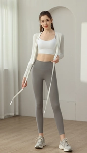 Detail view of women's yoga set with white tie-front cardigan and grey high waist leggings