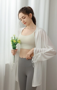 Detail of loose-fit white semi-transparent yoga sun-protection cover-up with drawstring cuffs