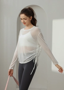 Detail of white mesh yoga cover-up featuring adjustable side drawstrings and breathable fabric
