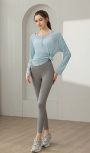 Détail du haut de yoga côtelé bleu clair à manches longues avec boutons et nœud à la taille
