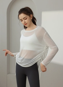 Detail of white mesh yoga top featuring adjustable side drawstrings and semi-transparent fabric