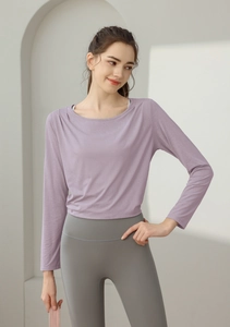Nahaufnahme des lila Langarm-Tops kombiniert mit einer grauen High-Waist Yoga-Leggings