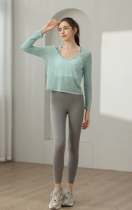 Détail d'un haut de yoga vert clair et d'un legging gris à taille haute de sport