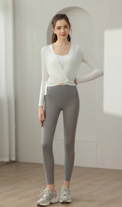 Detail of white long-sleeved yoga top with cross-strap design and matching sports bra