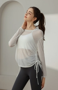 Detail of white mesh yoga cover-up featuring side drawstring ties and long sleeves