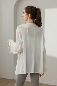 Back view of a breathable white long sleeve yoga cover-up with drawstring cuff details