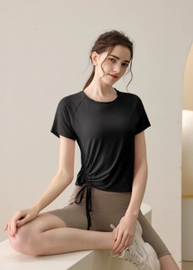 Detail of black drawstring yoga top with side pleat detail for fitness and gym wear
