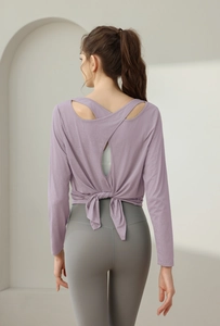 Detailansicht des lila Yoga-Oberteils mit offenem Rücken und Schleifen-Design