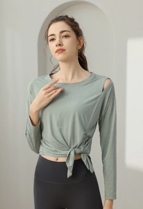 Detail of sage green yoga top with shoulder cut-out and tie-knot hem design