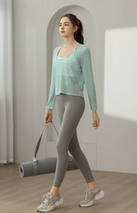 Vue détaillée latérale du haut de yoga vert clair ample et du legging gris taille haute