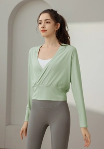 Gros plan d'un haut de yoga vert clair à coupe croisée montrant la texture douce du tissu