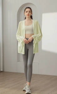 Detail of light green yoga cover-up with drawstring sleeves and slim white tank top