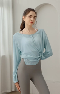Détail du haut de yoga bleu clair semi-transparent avec boutons et nœud à la taille