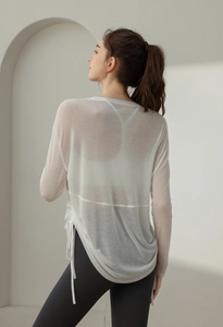 Detail of white long sleeve yoga cover up with side drawstring and mesh texture
