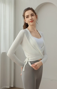 Detail view of white long sleeve yoga wrap top with front tie and slim fit design
