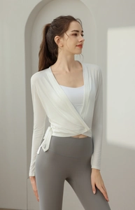 Macro shot of white tie-front yoga wrap top with breathable ribbed fabric texture