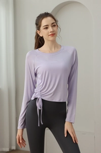 Detail view of adjustable side drawstrings on a slim-fit long-sleeve yoga top