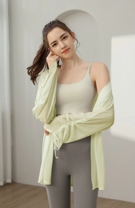 Detail of loose pale green sun-protection yoga shrug with drawstring cuffs and sports bra