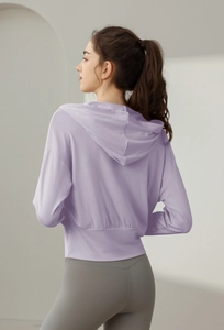 Vue arrière d'une veste de yoga courte violet clair avec capuche et ourlet élastique large