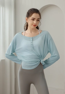 Détail du haut de yoga bleu clair avec tissu en maille respirant et boutons décoratifs