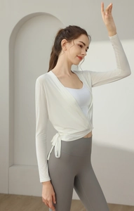Detail of white long sleeve yoga wrap top with cross tie design on professional fitness wear