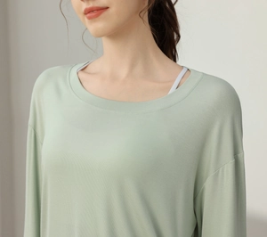 Details des hellgrünen, locker sitzenden Yoga-Tops mit weicher Textur und Rundhalsausschnitt