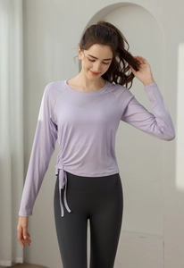 Detail of light purple yoga top featuring side drawstring ruching and ribbed texture