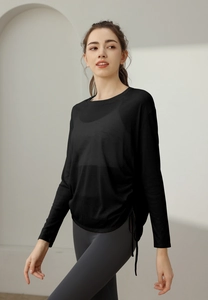 Detail of black sports top featuring adjustable side drawstrings and a round neckline