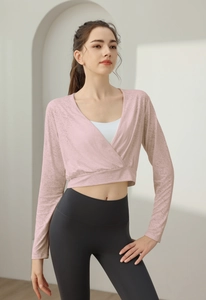Pink long-sleeve cross-neck yoga cover-up with textured fabric over white sports bra