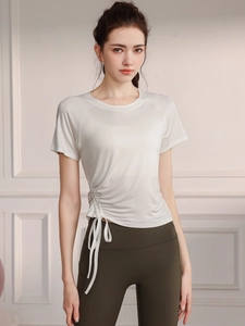 Short sleeve yoga top in beige with drawstring side and high waist green leggings