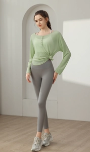 Détail d'un haut de yoga vert clair avec boutons et nœud latéral élégant sur le côté