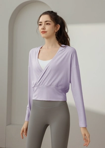 Détail d'un haussement d'épaules de sport lilas croisé avec un legging de yoga gris