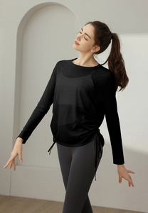 Detail of black athletic long sleeve shirt with adjustable side drawstring and loose fit