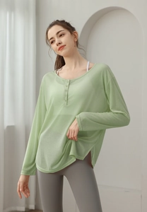 Détail du haut de yoga en mesh vert clair avec boutons Henley et texture respirante