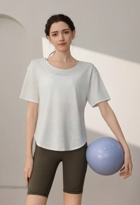 Detail of white quick-dry fitness T-shirt and olive green cycling shorts with yoga ball