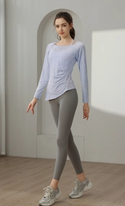 Detail of light purple long sleeve yoga top with ruched sides and high waist gray leggings