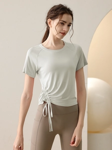 Women's light green drawstring workout top and high-waisted yoga pants set