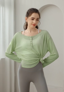Détail d'un haut de yoga vert clair avec col henley et bas noué pour le sport