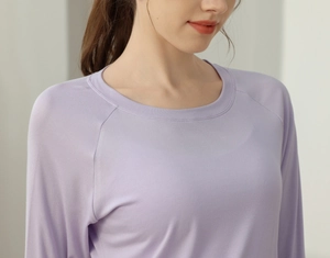 Detail view of the lavender drawstring yoga top showing raglan sleeves and smooth texture