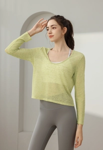 Détail du haut de yoga vert herbe fin montrant la texture en maille et la coupe ample