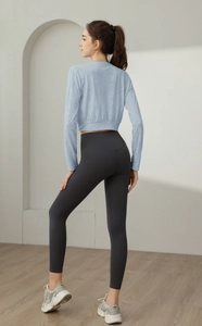 Detail of light blue nylon yoga top and charcoal high waist compression leggings set
