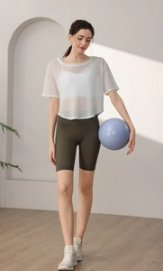 Détail du haut de yoga en maille blanche et du short de cycliste vert olive à taille haute