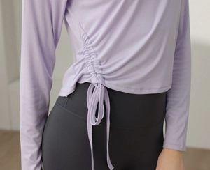 Detail view of adjustable side drawstrings on slim fit lavender yoga long sleeve top