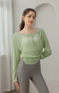 Détail du haut de yoga vert clair avec col boutonné et nœud latéral décoratif